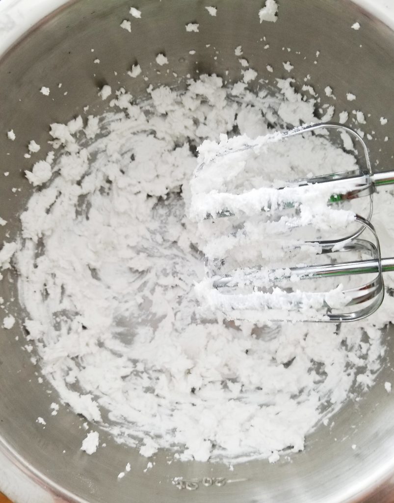 beating coconut cream in a stainless steel bowl