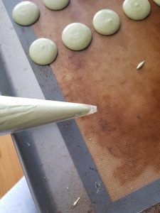 using a piping bag for the matcha macarons 