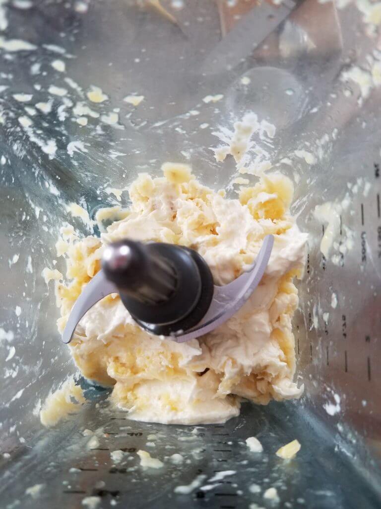 pineapple banana smoothie in a blender with some chunks not blended in totally 