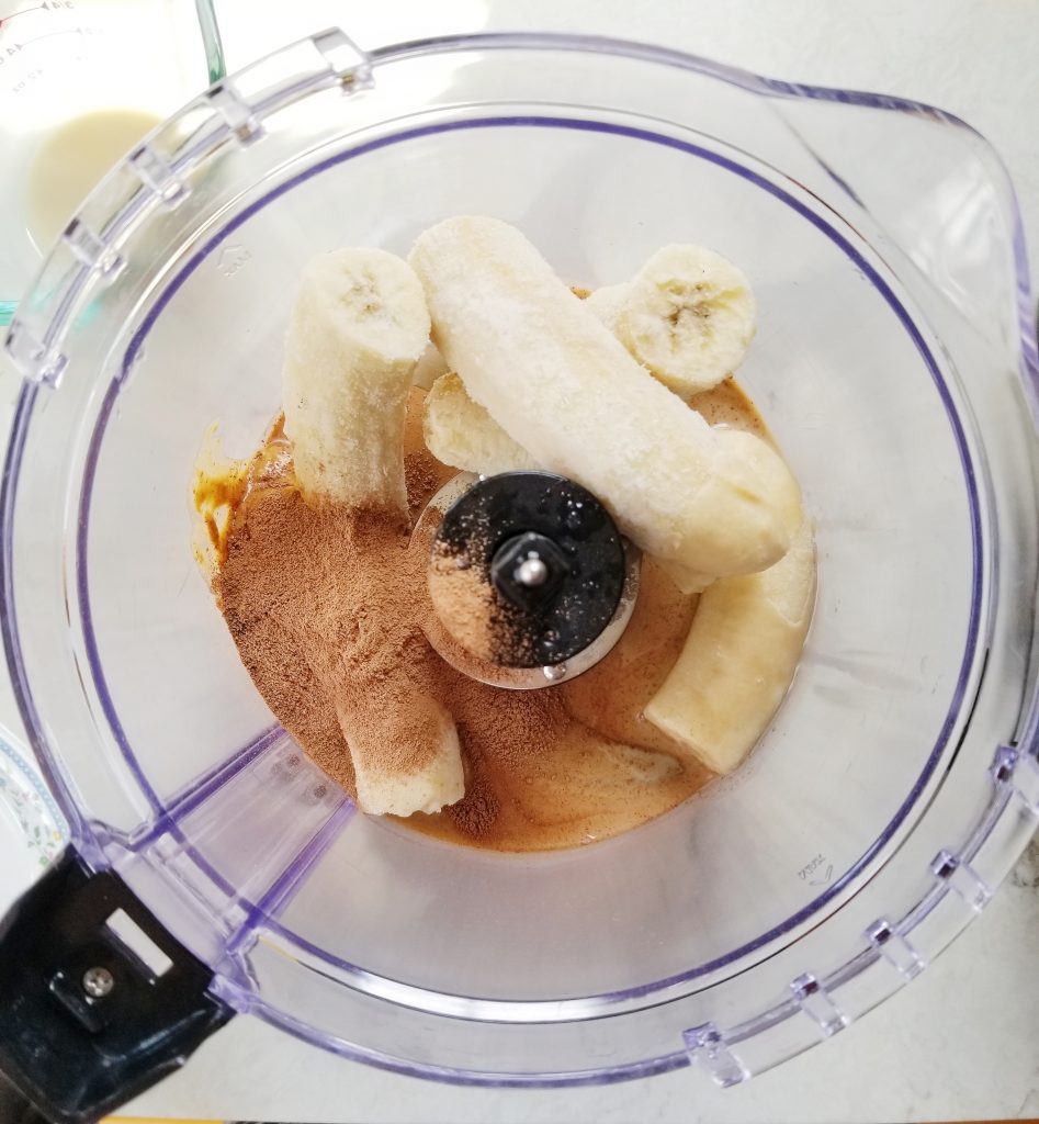 frozen bananas in food processor with chocolate powder and peanut butter