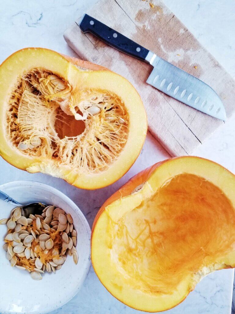 2 pumpkin halves with seeds scraped out of 1 half