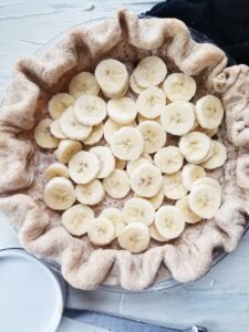 sliced bananas in baked pie shell