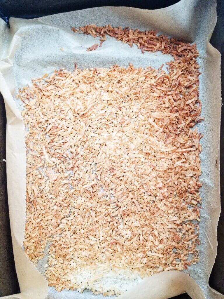 toasted coconut flakes on a baking sheet