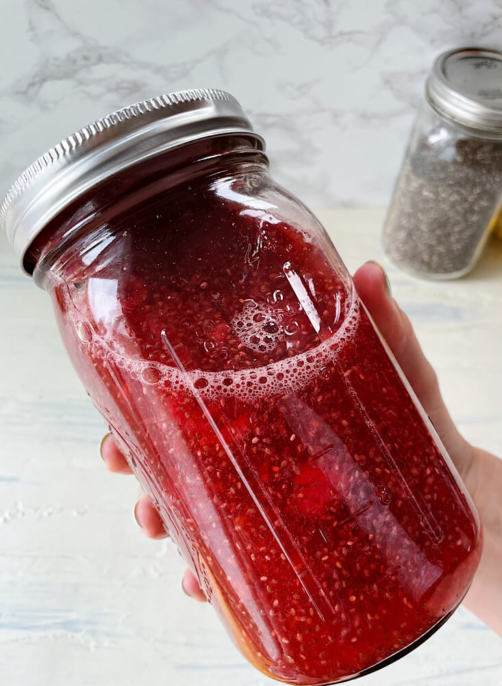red raspberry chia seed water with lemon in a mason jar 
