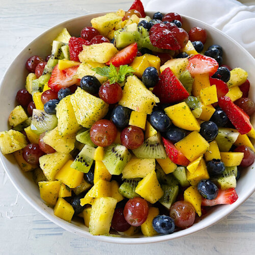 rainbow fruit salad in a white bowl