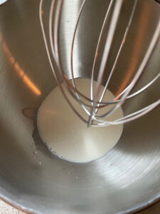 heavy whipping cream and rose essence in a standing mixer