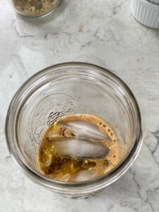 espresso with olive oil and ice cubes in a mason jar